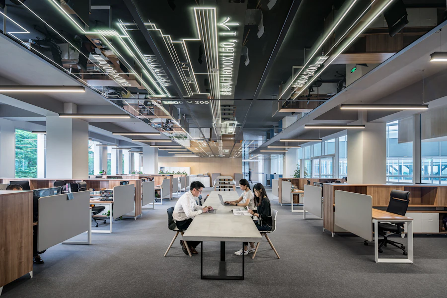 Espaço de trabalho de escritório com mesas, plantas e iluminação natural